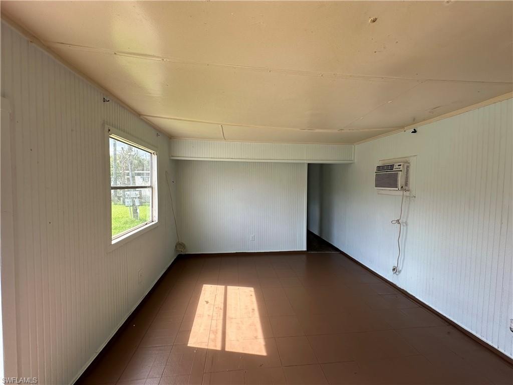 Unfurnished room featuring tile patterned flooring and a wall mounted air conditioner
