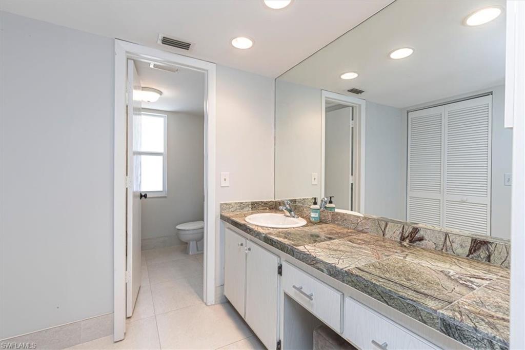Bathroom with vanity, light tile patterned floors, and recessed lighting