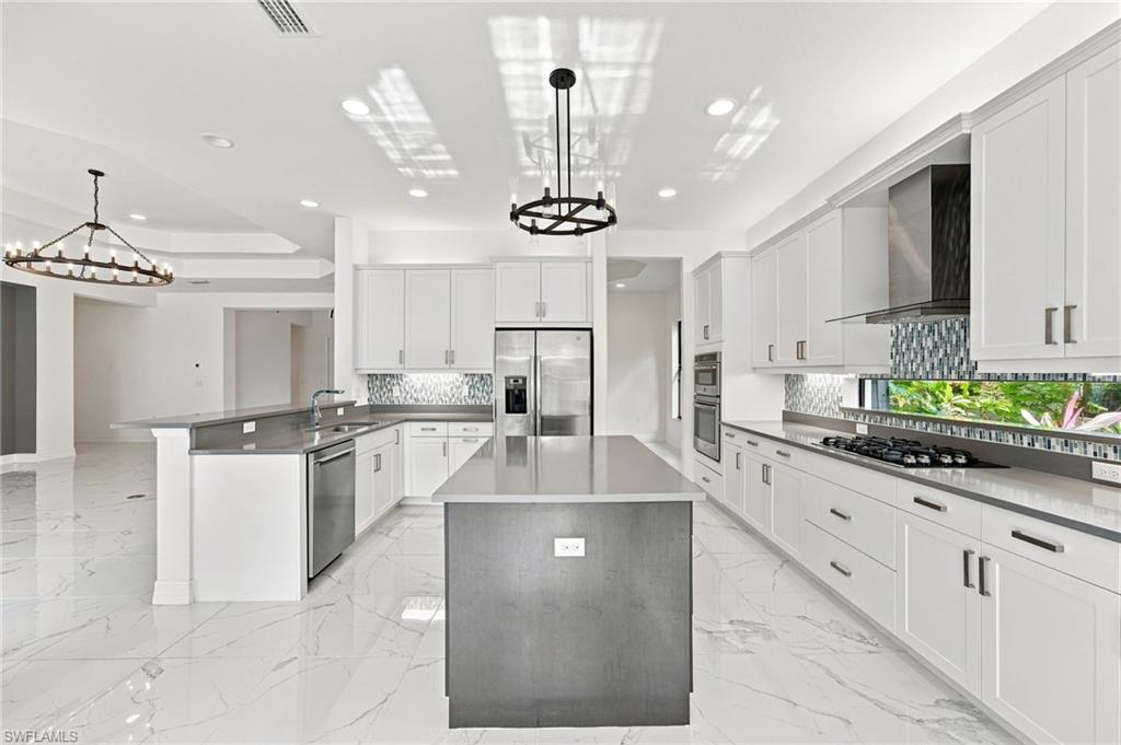 Gourmet kitchen with island, quartz counter top, transom window, vented hood to outside