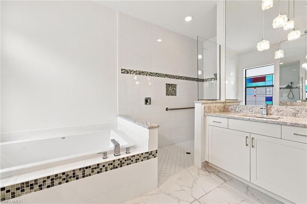 Primary ensuite bathroom with Roman soaking tub, dual vanities, luxury finishes.