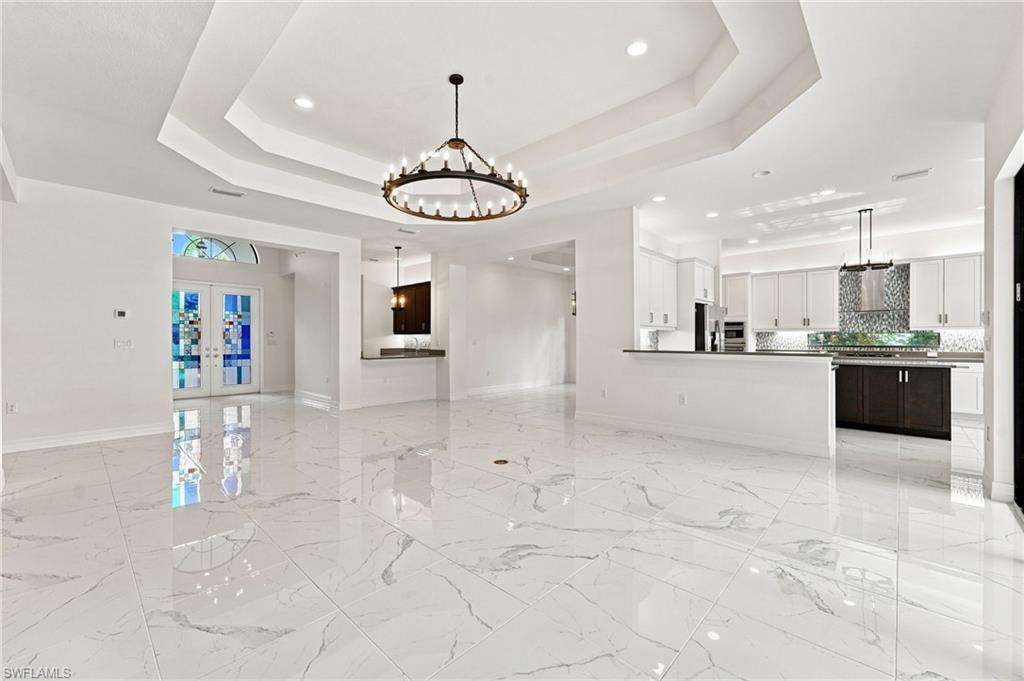 Massive great room with kitchen counter top bar seating, wet bar, formal dining room, foyer entrance.