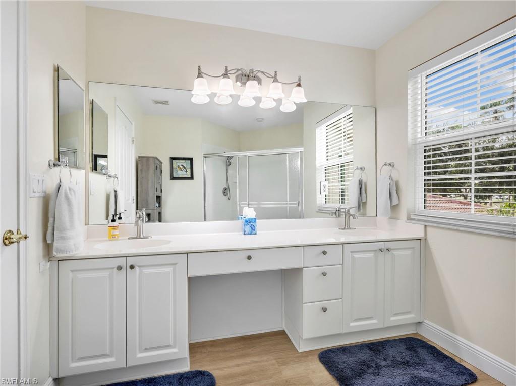 Dual vanity with white cabinetry, integrated sink, and brushed nickel fixtures