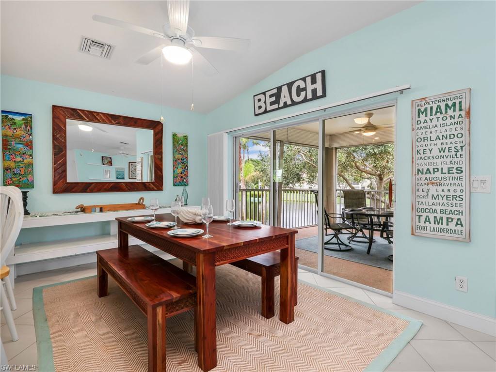 Vaulted ceiling with a ceiling fan, sliding glass door, and tile flooring