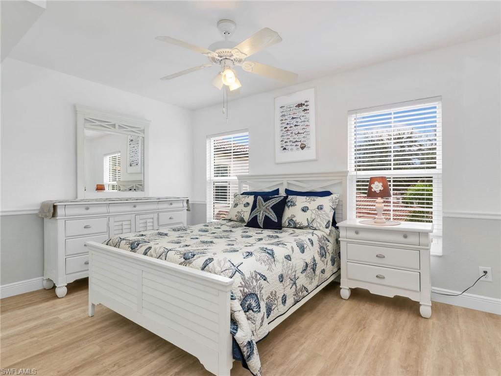 Recessed lighting, wood-finish flooring, two windows with blinds, crown molding, and a ceiling fan with integrated lighting