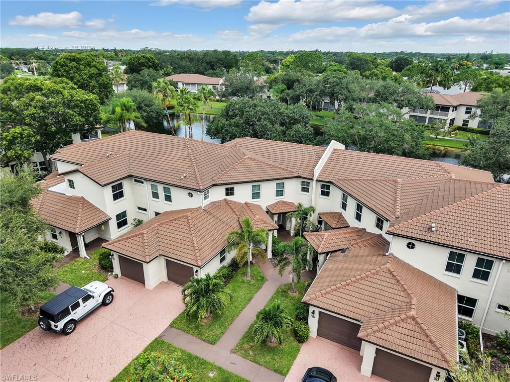 Multi-story residence featuring a tile roof, stucco exterior, and attached garages