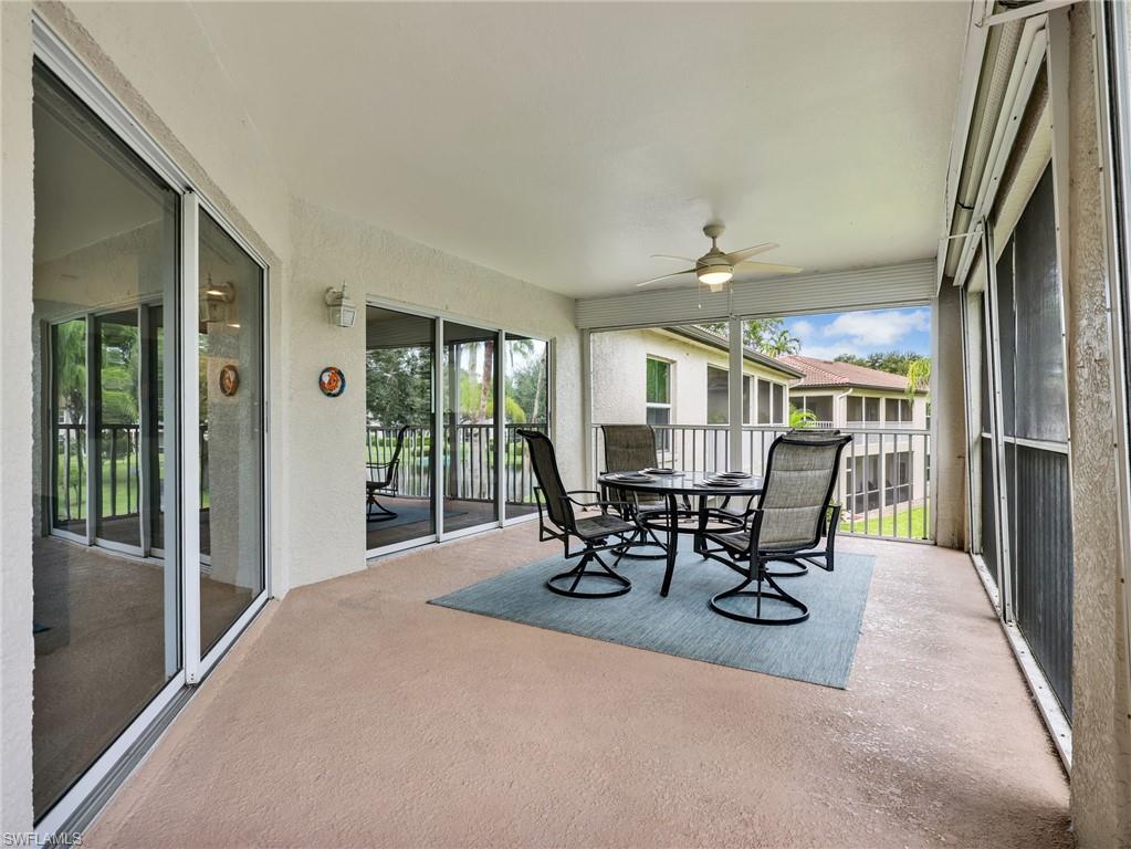 Screened lanai featuring a textured concrete floor, ceiling fan, and multiple sets of sliding glass doors