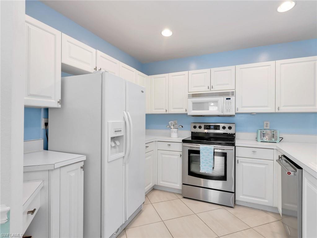 Kitchen featuring white cabinetry, white countertops, stainless steel appliances, and tile flooring