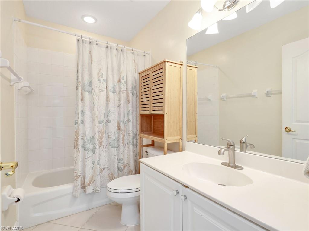 White vanity with integrated sink, brushed nickel faucet, and a large wall-mounted mirror