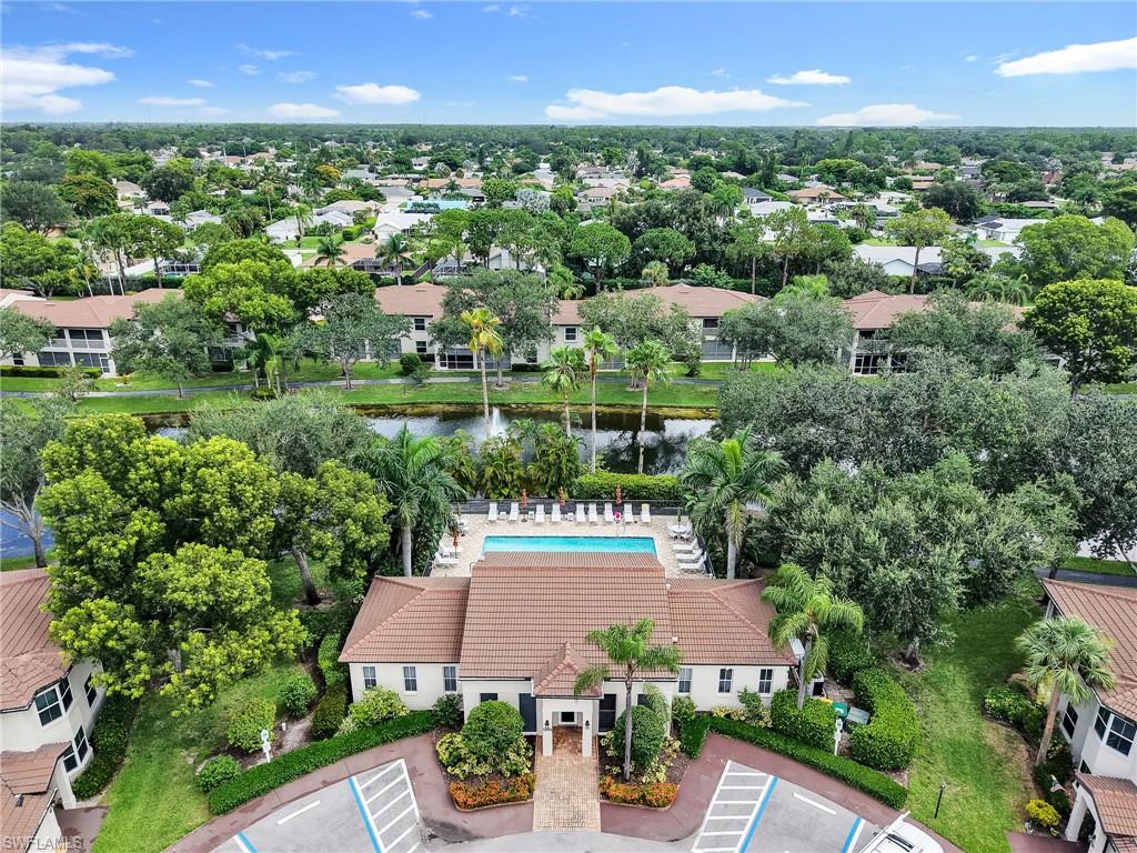 Community building featuring a swimming pool, surrounding lounge area, and mature landscaping