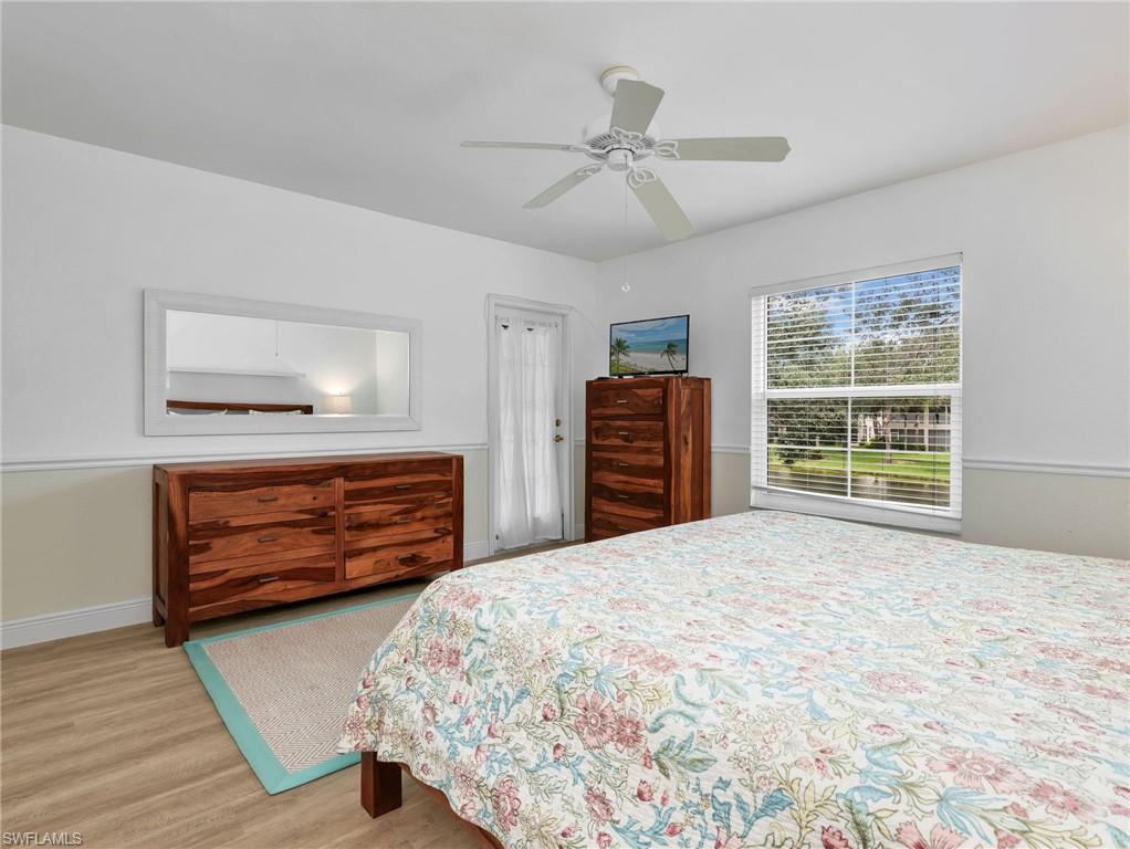 Wood-finish flooring, white ceiling fan, and a single window with horizontal blinds