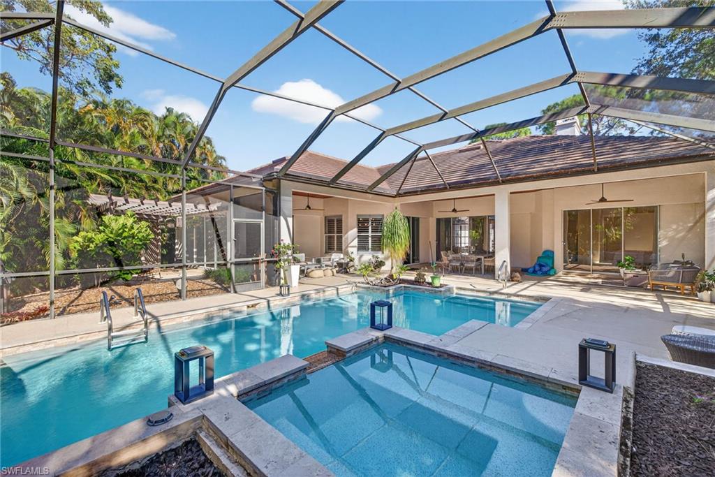 View of pool with glass enclosure, a sunroom, a pool with connected hot tub, and a patio