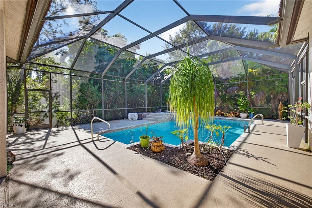 Outdoor pool featuring glass enclosure, a sunroom, and a patio