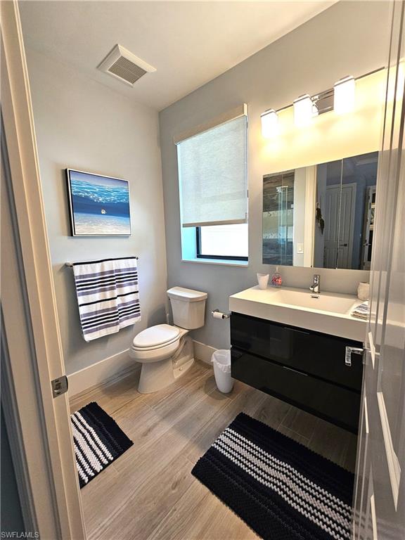 Bathroom featuring vanity, light wood-type flooring, and a shower with shower door