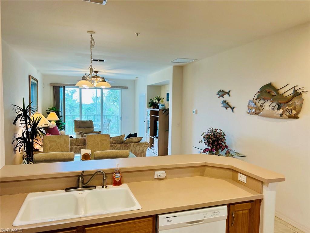 Integrated kitchen counter with a double-basin sink, a built-in dishwasher, and wood-finish cabinetry