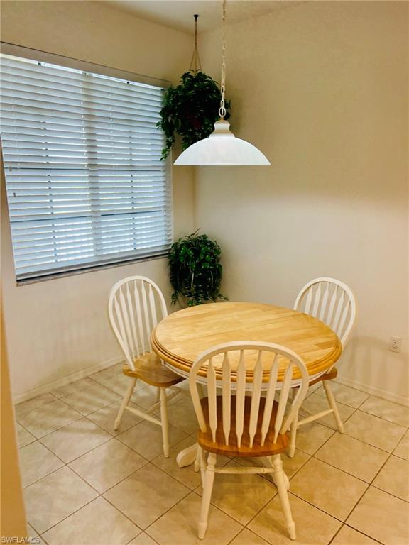 Tiled flooring with a window featuring horizontal blinds and a ceiling-mounted pendant light fixture