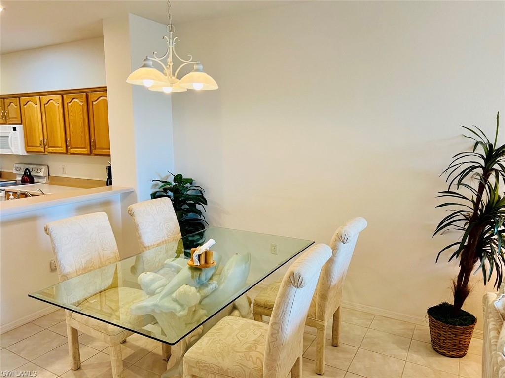 Tiled flooring throughout with a kitchen pass-through, overhead lighting, and light wood-finish cabinetry
