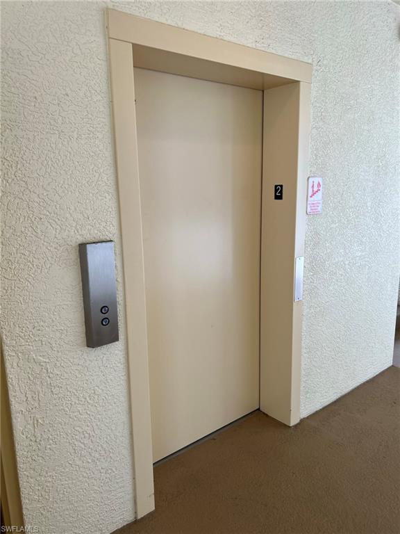 Elevator access with a neutral door and stainless steel call buttons
