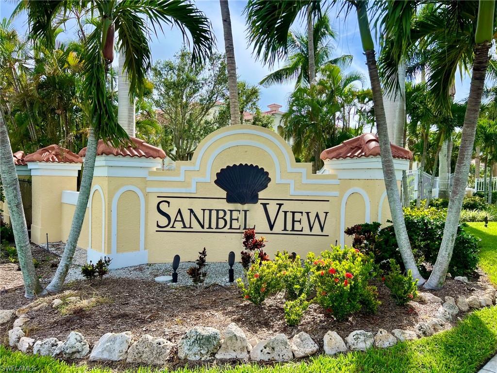 Sanibel View property entrance with a decorative sign, terracotta tile accents, and lush landscaping