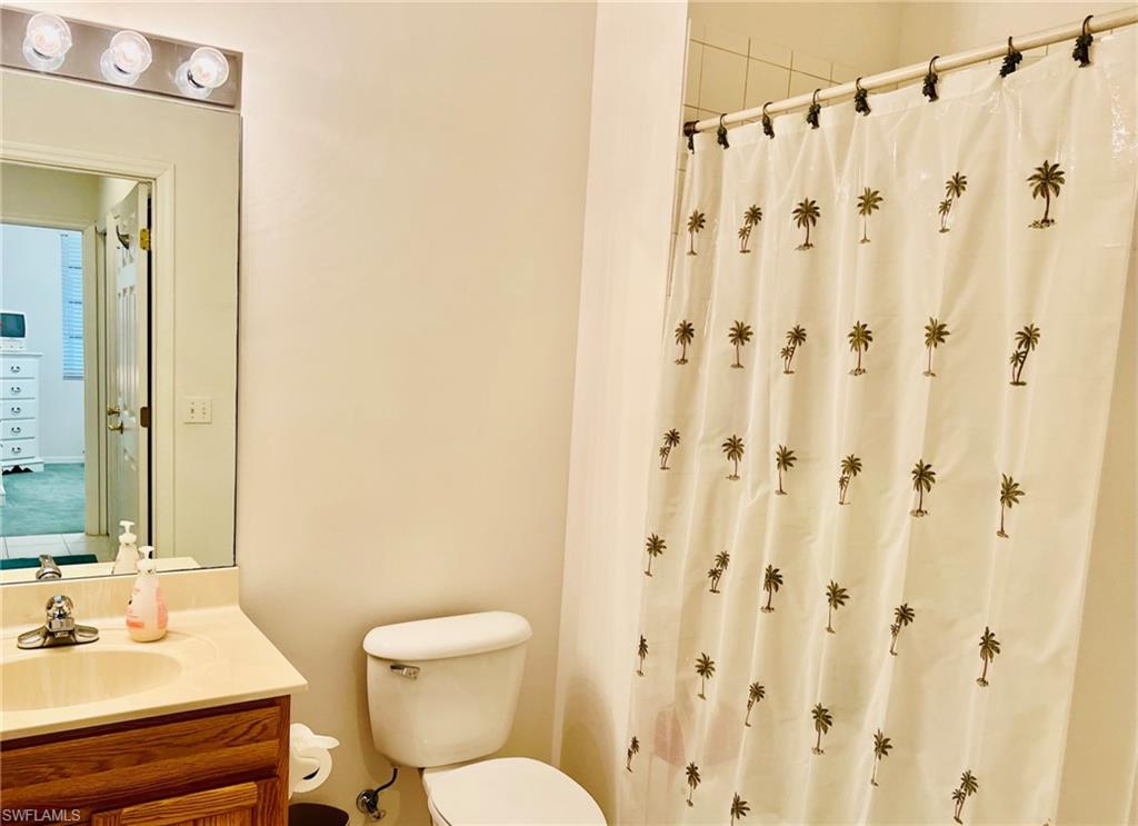 White tiled shower with an adjacent toilet