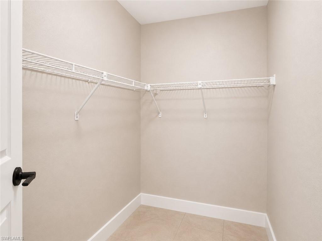 Corner wire shelving system with light-toned wall finishes and tile flooring