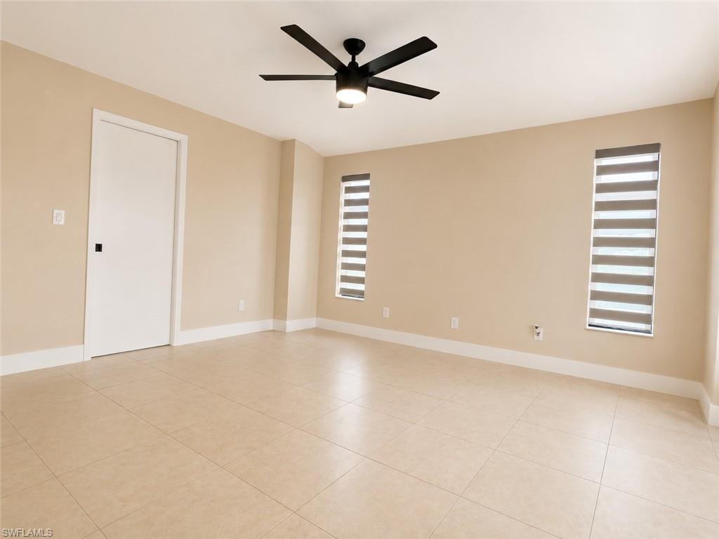 Tile flooring throughout with integrated baseboards, featuring a contemporary ceiling fan with integrated lighting