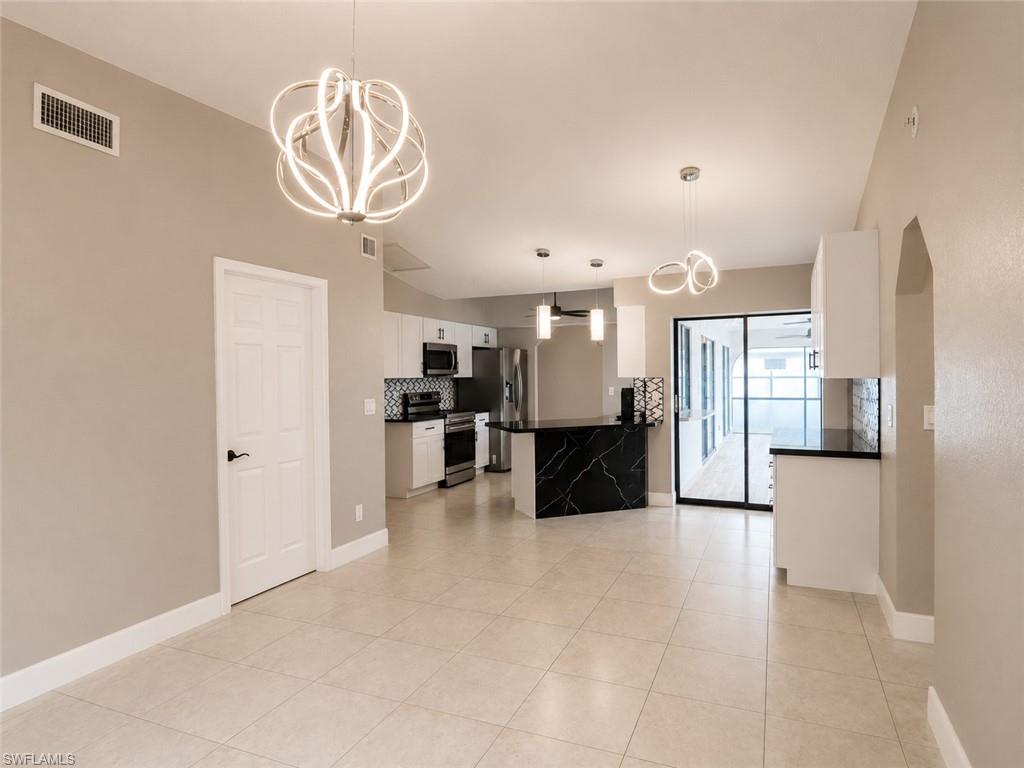 Open-concept living area featuring large format tile flooring and vaulted ceilings