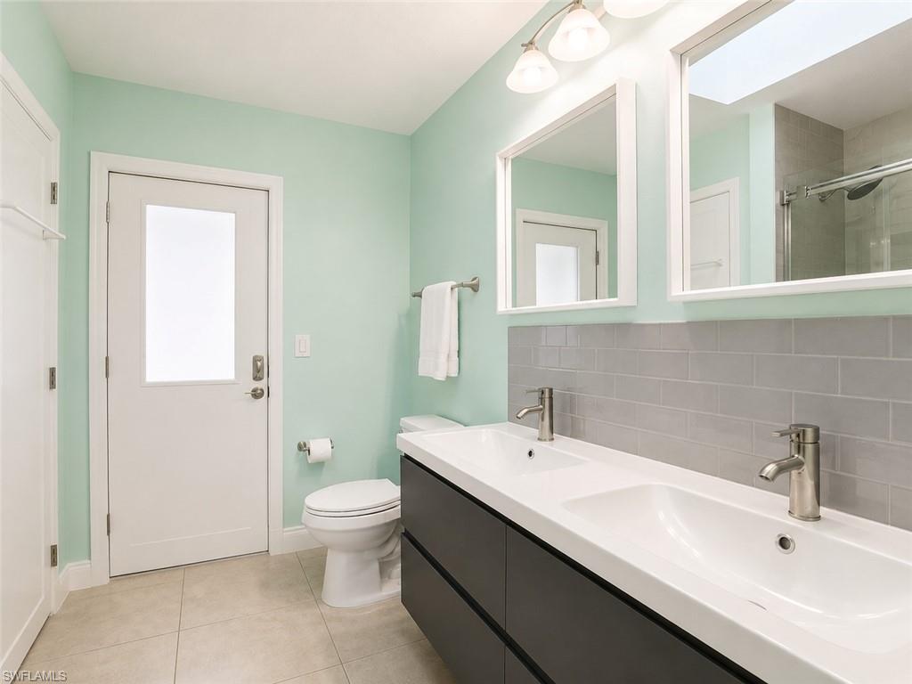 Dual vanity with integrated sinks, brushed nickel faucets, and dark wood-finish cabinetry