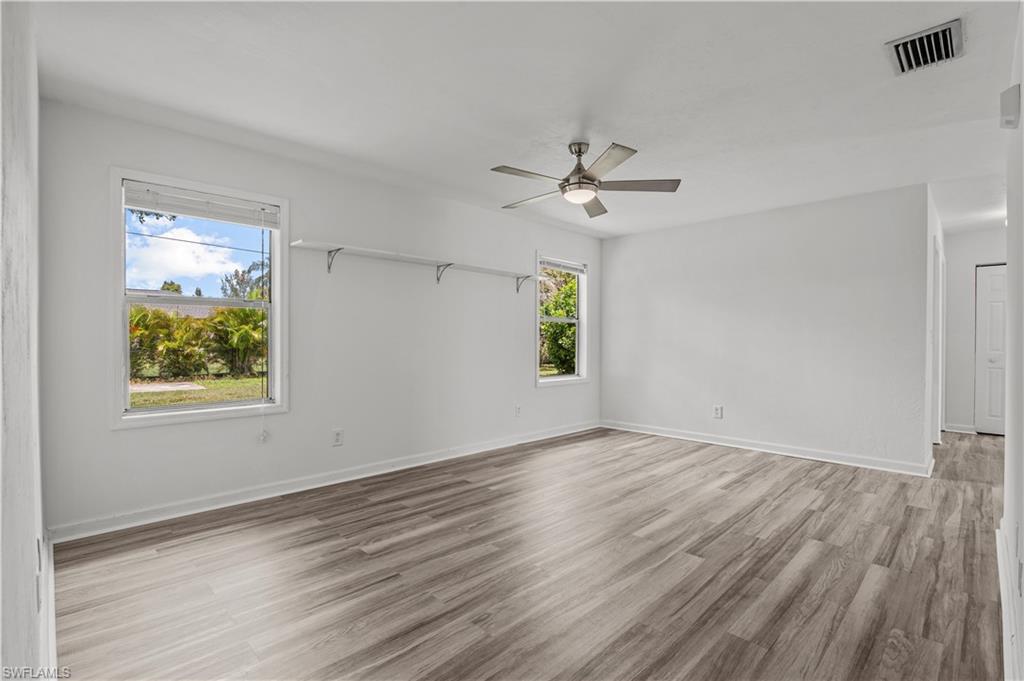 Unfurnished room featuring a wealth of natural light, light tile wood style flooring, and ceiling fan
