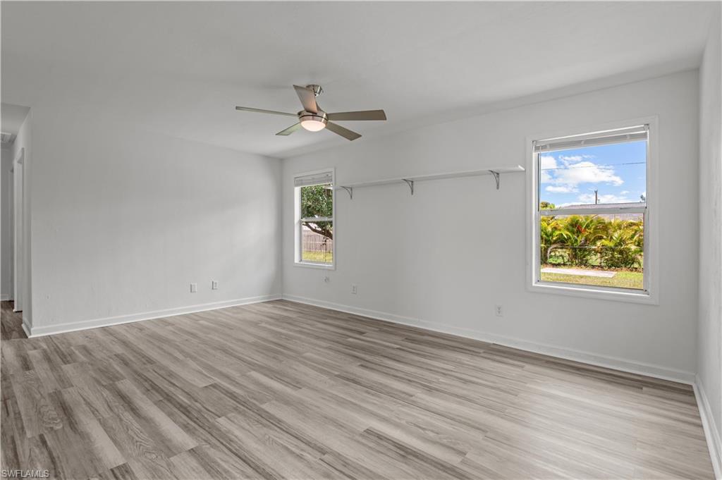 Living room with ceiling fan, light hardwood / wood-style flooring, and a wealth of natural light