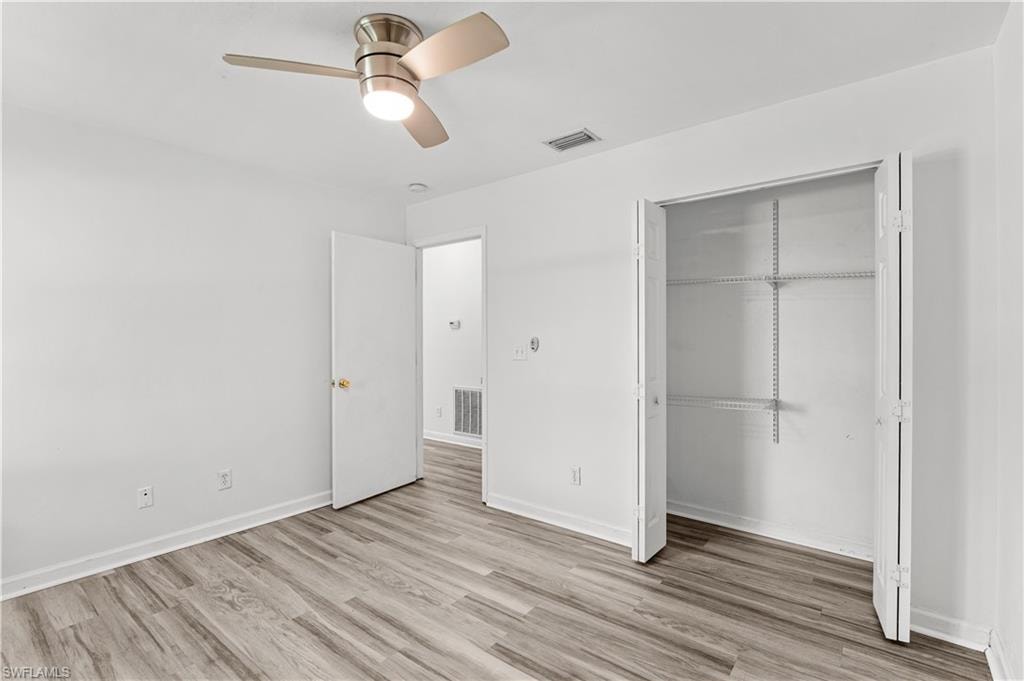 Unfurnished bedroom featuring a closet, ceiling fan, and light hardwood / wood-style flooring