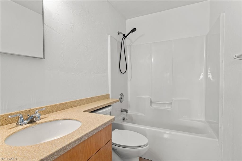 Full bathroom featuring tub / shower combination, vanity, and toilet