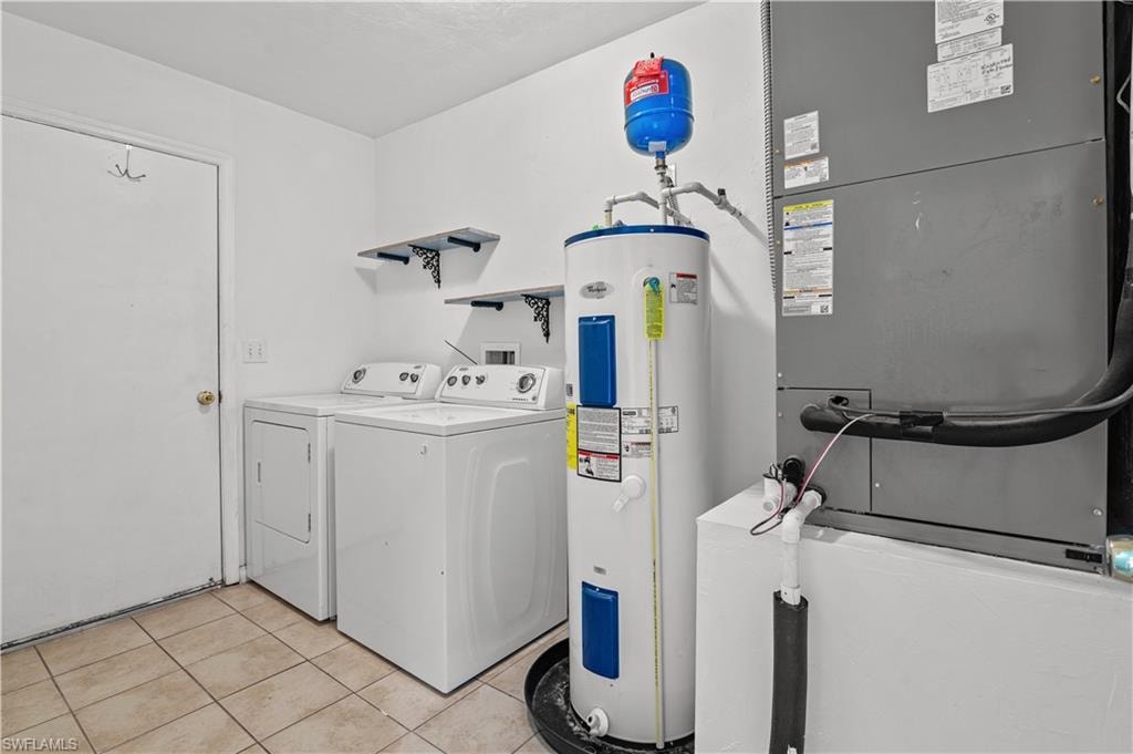 Laundry room with independent washer and dryer, heating utilities, washer hookup, water heater, and light tile floors