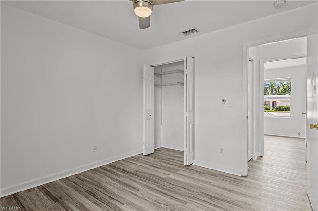 Unfurnished bedroom featuring ceiling fan, a closet, and light hardwood / wood-style floors