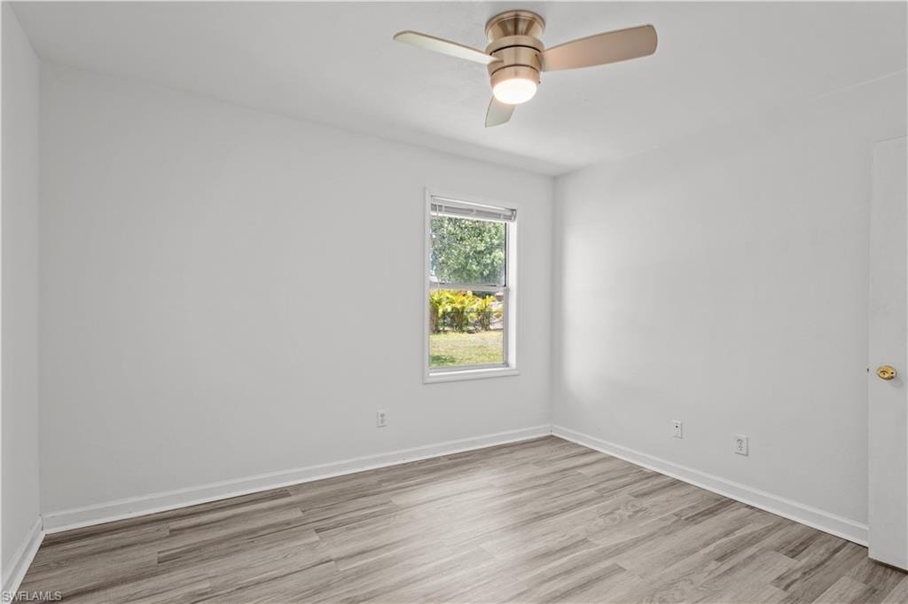 Empty room with ceiling fan and light hardwood / wood-style floors