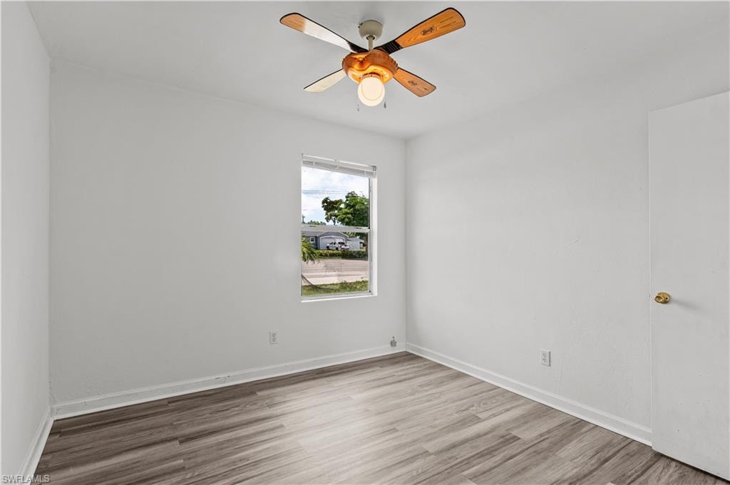Unfurnished room with hardwood / wood-style floors and ceiling fan