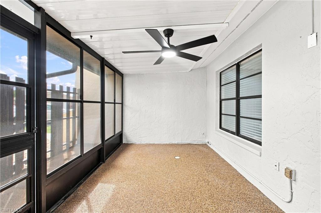 Bright, elongated view of the screened porch highlighting the high ceiling, clean lines, and crisp window framing looking back toward the home.
