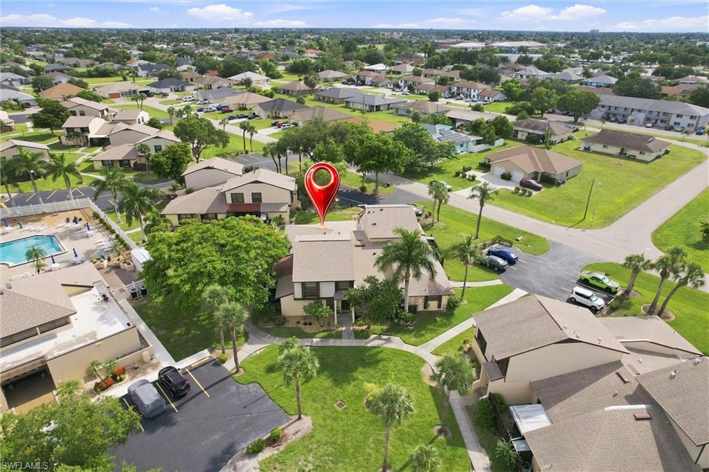 Prime location! Aerial view showcases the property’s close proximity to the community pool, convenient open parking and beautifully landscaped common areas.