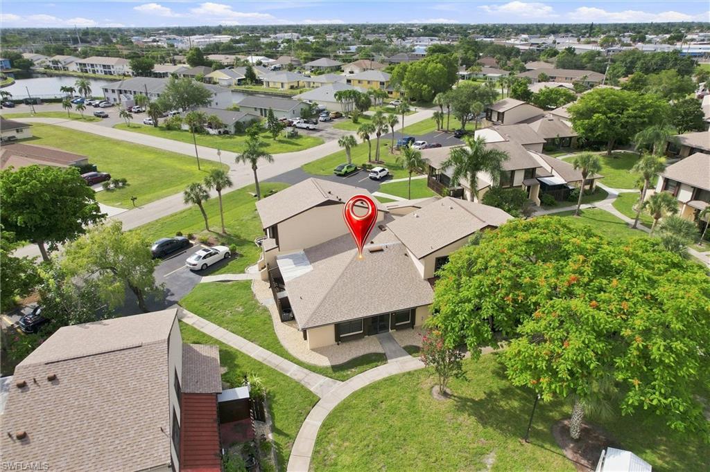 High-altitude aerial view highlights the home's prominent corner layout and extensive surrounding green space.