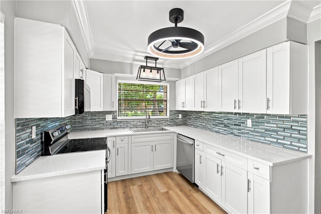 Plentiful counter space and cabinet storage make meal prep a breeze in this sleek, thoroughly modernized kitchen layout.