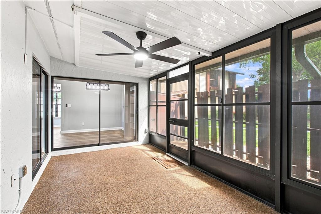 Covered lanai retreat features durable flooring, textured privacy accent walls, and direct exterior door access to the side yard.