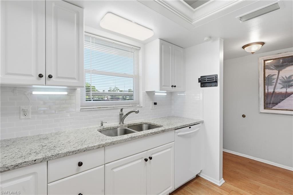 "COASTAL" UPDATED KITCHEN WITH RAISED PANEL CABINETRY, GRANITE COUNTERS, SUBWAY TILE BACKSPLASH, TRAYED CEILING, CUSTOM LIGHTING, AND IMPACT WINDOW...