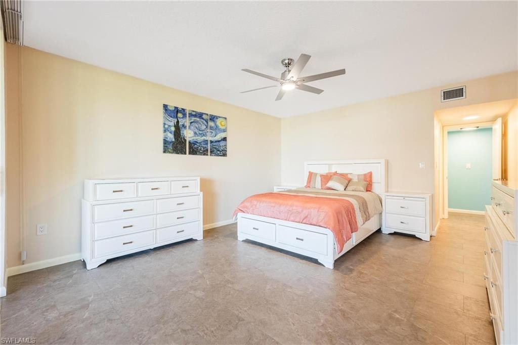 Spacious room featuring neutral wall tones, durable wood-finish flooring, and a ceiling fan with integrated lighting