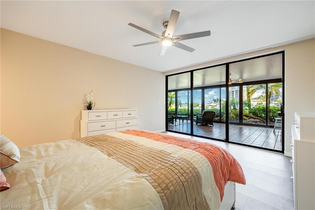 Expansive sliding glass doors opening to a tiled outdoor space with lush tropical landscaping