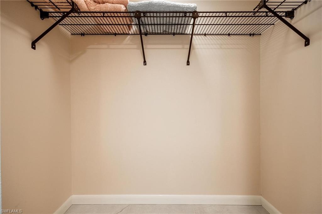 Walk-in closet with wire shelving system and light-toned walls