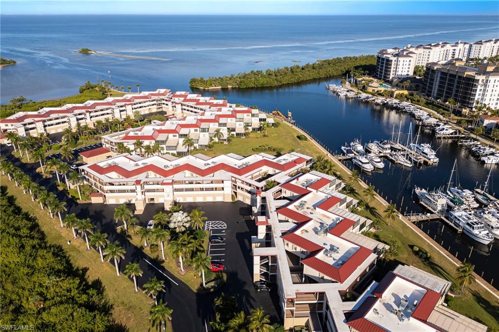 Coastal community featuring waterfront properties, a private marina with multiple boat slips, extensive landscaping with palm trees, and direct access to open water