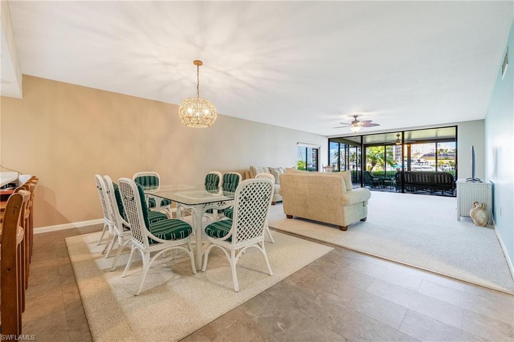 Open-concept dining and living areas featuring a decorative chandelier, recessed lighting, and expansive glass sliders
