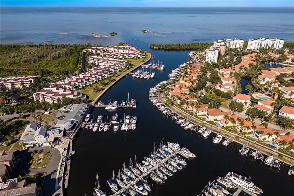 Aerial perspective showcasing a marina with numerous boats, bordered by residential properties and open water