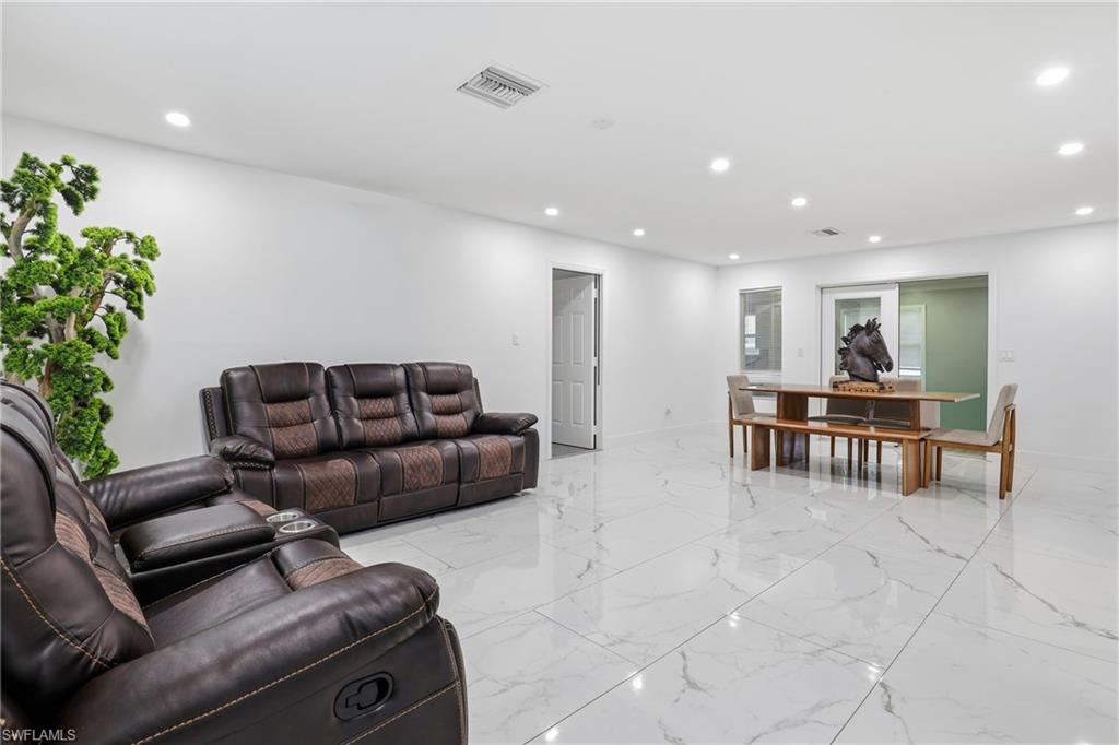 White walls with recessed lighting, large format tile flooring, and sliding glass doors