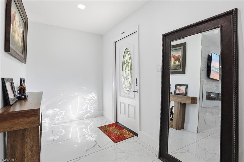 White paneled entry door with oval leaded glass insert