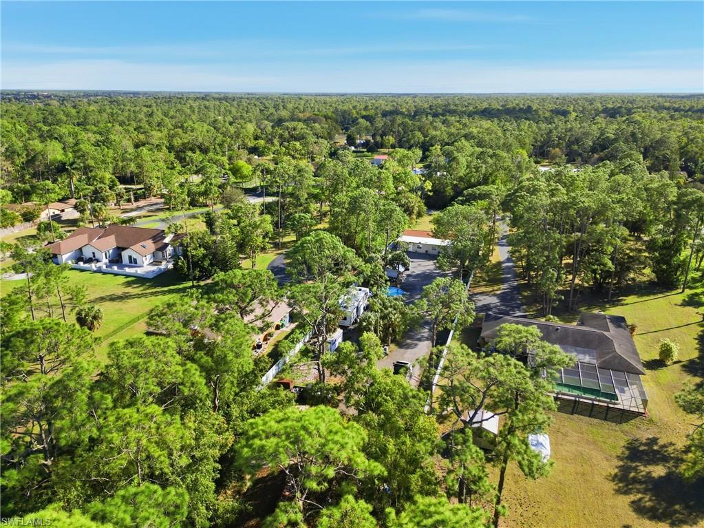 Extensive tree coverage, multiple structures, and a swimming pool with a screened enclosure